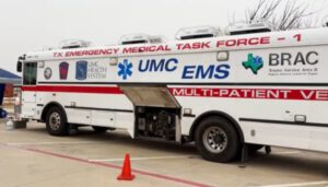 A TX Emergency Medical Task Force multi-patient vehicle from UMC EMS parked outside, equipped for emergency medical response during a health crisis in Texas.