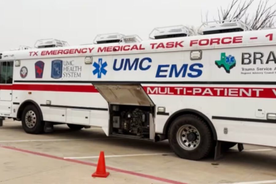 A TX Emergency Medical Task Force multi-patient vehicle from UMC EMS parked outside, equipped for emergency medical response during a health crisis in Texas.