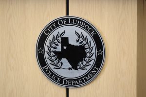 Seal of the City of Lubbock Police Department displayed on a wooden wall, featuring the state of Texas with a star marking Lubbock’s location.