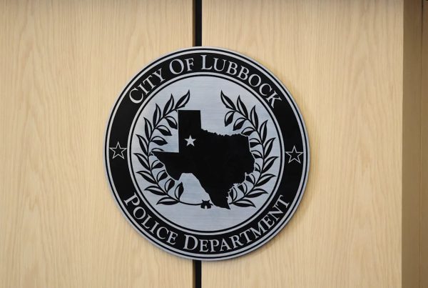 Seal of the City of Lubbock Police Department displayed on a wooden wall, featuring the state of Texas with a star marking Lubbock’s location.