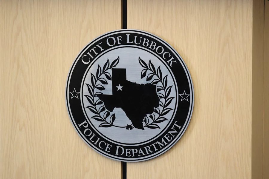 Seal of the City of Lubbock Police Department displayed on a wooden wall, featuring the state of Texas with a star marking Lubbock’s location.
