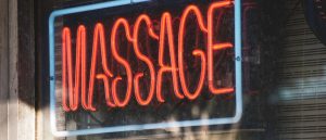 Neon massage sign in window, representing a Lubbock massage parlor recently shut down and permanently banned by TDLR due to human trafficking investigation.