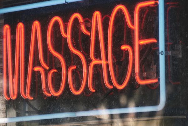 Neon massage sign in window, representing a Lubbock massage parlor recently shut down and permanently banned by TDLR due to human trafficking investigation.