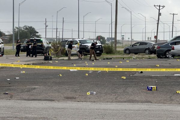 Police investigate officer-involved shooting scene on Parkway Drive in Lubbock, Texas, marked by evidence tags and crime scene tape following early morning gunfire on July 5, 2025.