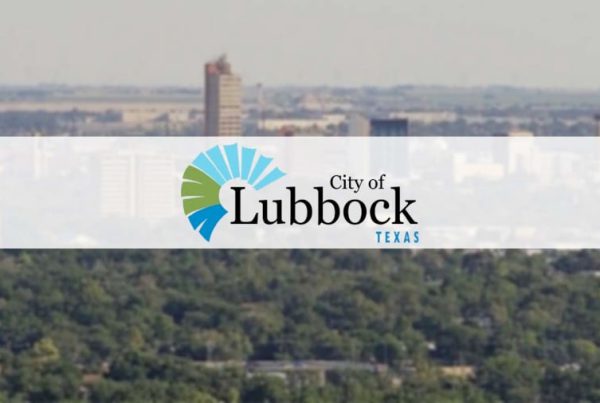 City of Lubbock, Texas logo over a skyline view of the city with trees and buildings in the background.