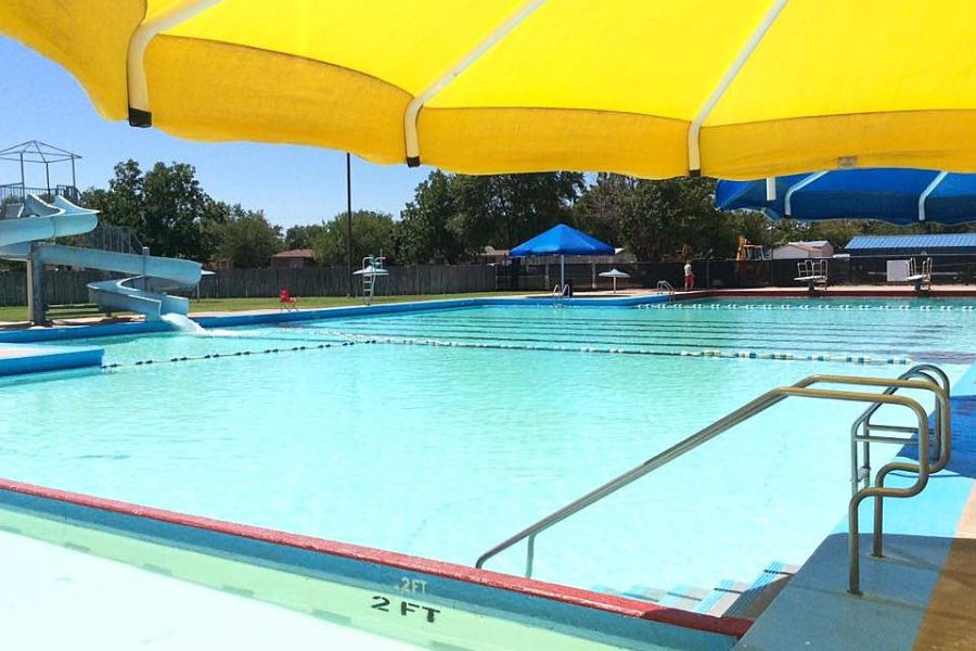 Empty Clapp Pool in Lubbock, Texas, under yellow umbrella during summer closure.