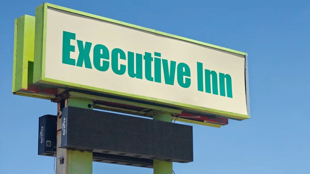 Executive Inn sign at 4401 Avenue Q in Lubbock, Texas, hotel under police scrutiny for shootings and ongoing criminal activity.