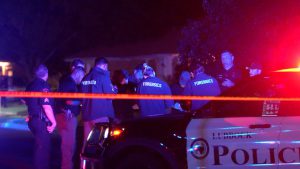 Lubbock police and forensic investigators work a crime scene behind police tape after a deadly shooting at a short-term rental party on 76th Street.