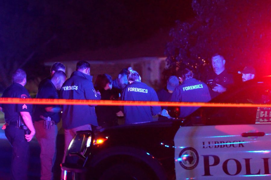 Lubbock police and forensic investigators work a crime scene behind police tape after a deadly shooting at a short-term rental party on 76th Street.