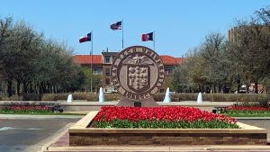 Texas Tech University seal with red flowers, fountains, and campus buildings in the background.