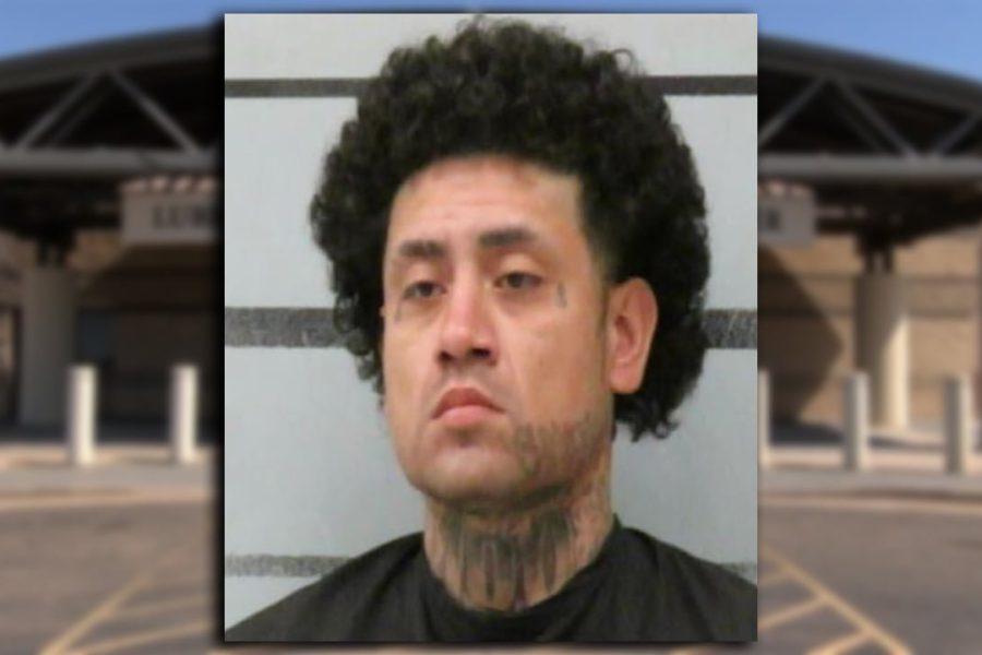 Mugshot of Joe Lopez with curly hair and neck tattoos in front of a jail booking wall.