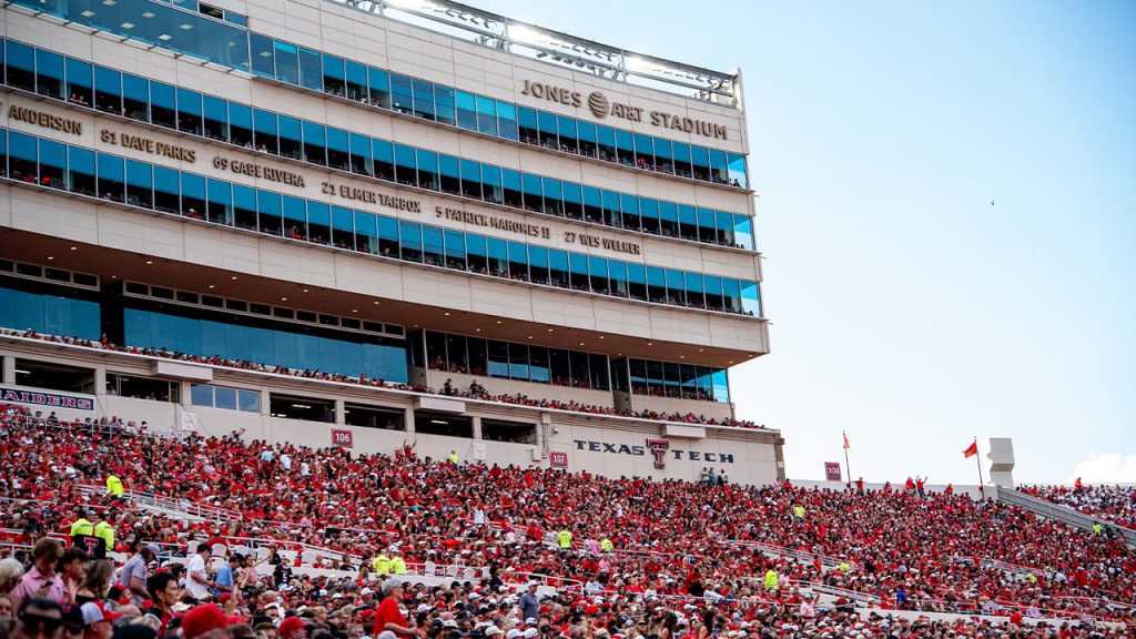 Crowd of Texas Tech fans in red filling the stands at Jones AT&T Stadium in Lubbock, Texas, during a home football game.