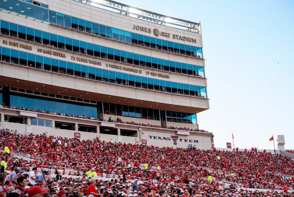 Crowd of Texas Tech fans in red filling the stands at Jones AT&T Stadium in Lubbock, Texas, during a home football game.