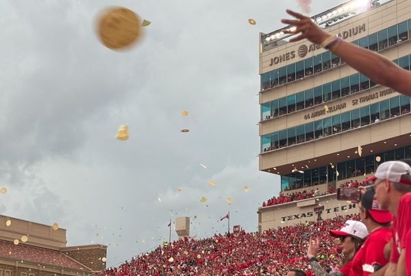 Tortillas flying through the air at Jones AT&T Stadium as Texas Tech fans celebrate kickoff during a home football game.