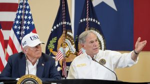Gov. Greg Abbott gestures beside Donald Trump during a press event, highlighting their close political alignment despite past states’ rights rhetoric.