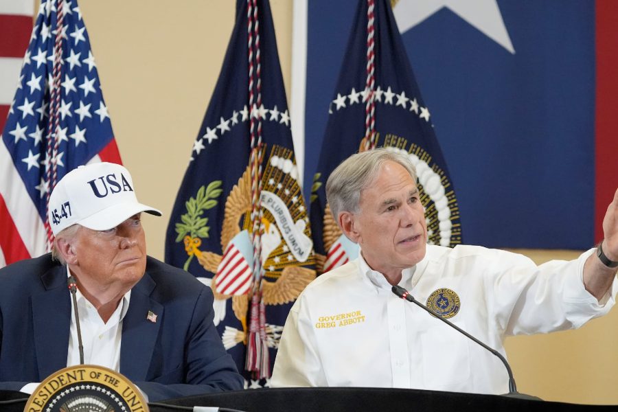 Gov. Greg Abbott gestures beside Donald Trump during a press event, highlighting their close political alignment despite past states’ rights rhetoric.