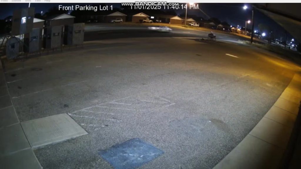 Surveillance camera image showing a white car speeding down 82nd Street in south Lubbock moments before a hit-and-run on November 1, 2025.
