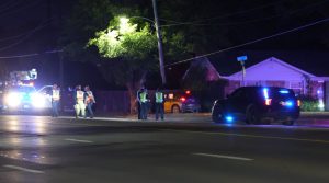 Police lights and utility crews on Slide Road at night after a car chase ended in a crash with a pole and tree in Lubbock.