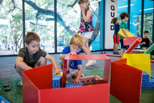 Children in a classroom play area building with large foam blocks during a pre-K activity, illustrating early childhood education settings affected by Texas’ new school voucher rules.