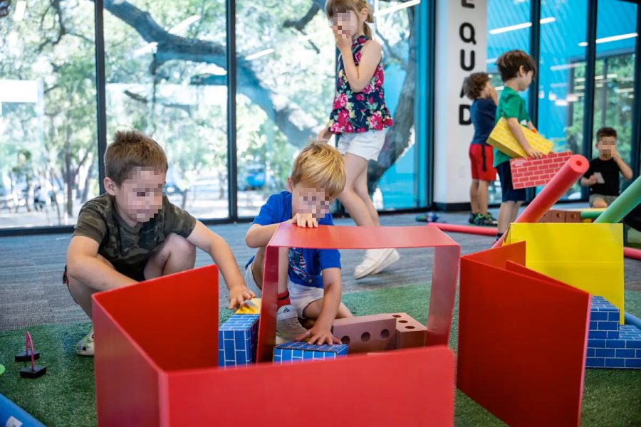 Children in a classroom play area building with large foam blocks during a pre-K activity, illustrating early childhood education settings affected by Texas’ new school voucher rules.