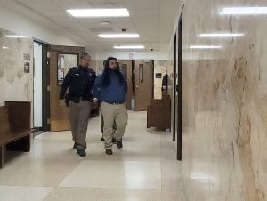 Timothy Gonzalez escorted by a law enforcement officer through the Lubbock County Courthouse hallway during his sentencing for a deadly 2021 drunk driving crash.