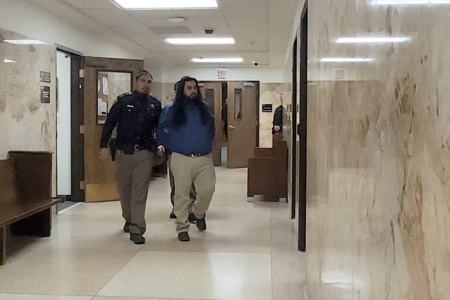 Timothy Gonzalez escorted by a law enforcement officer through the Lubbock County Courthouse hallway during his sentencing for a deadly 2021 drunk driving crash.