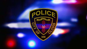 Clovis Police Department badge over blurred red and blue emergency lights in Clovis, New Mexico.