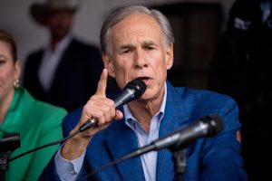 Texas Governor Greg Abbott speaks into a microphone and gestures during a press event discussing his property tax proposals.