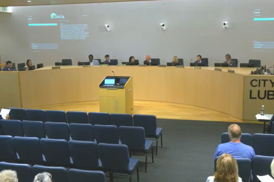 Wide view of the Lubbock City Council chamber during a public meeting, showing council members seated at the front and a few attendees in the audience.