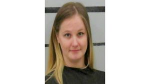 Booking photo of an adult woman with long blond hair wearing a dark jail garment, photographed against a height-strip background following a DWI arrest in Lubbock.