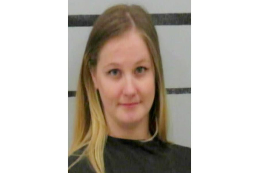 Booking photo of an adult woman with long blond hair wearing a dark jail garment, photographed against a height-strip background following a DWI arrest in Lubbock.