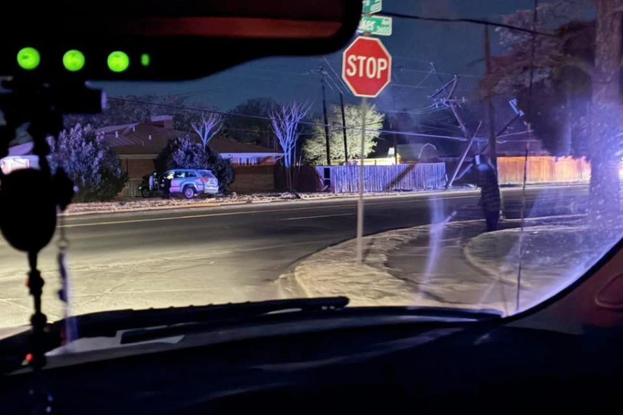 Nighttime photo of a crashed SUV and leaning utility poles at the intersection of 37th Street and Quaker Avenue in Lubbock after a suspected DWI accident that caused a major power outage.