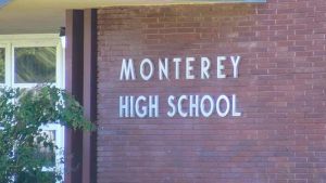 Exterior brick wall and entrance sign of Monterey High School in Lubbock, Texas.