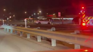 Nighttime crash scene on Spur 327 at the West Loop frontage road in Lubbock with emergency vehicles responding after a three-vehicle collision.
