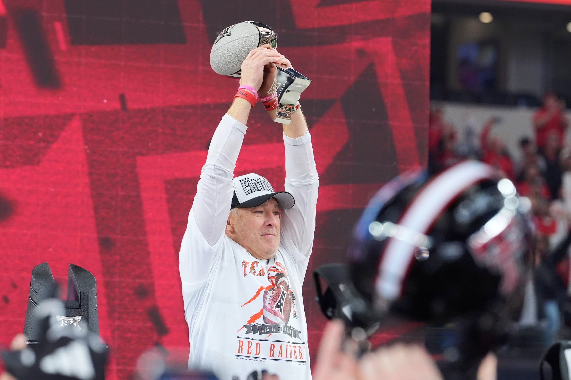 Texas Tech head coach Joey McGuire lifts the Big 12 championship trophy during a Red Raiders football celebration.