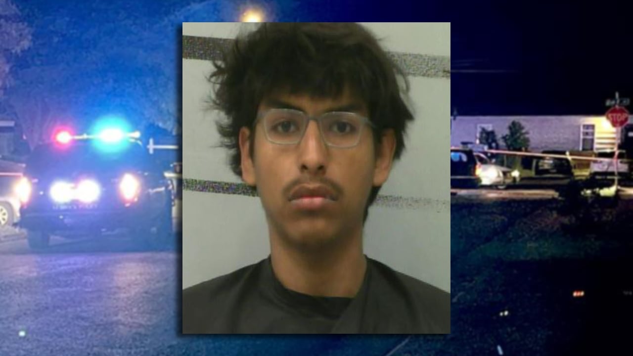 Booking photo of Adam Villarreal charged in a Central Lubbock drive-by shooting case, with police lights in the background.