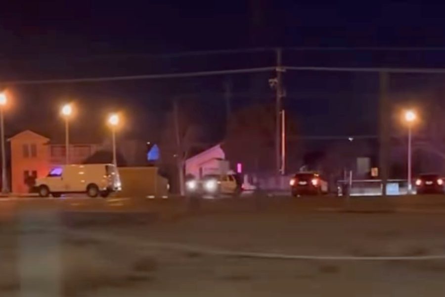 Nighttime scene near 18th Street and Avenue U in Lubbock showing police vehicles and flashing lights at the location of an officer-involved shooting investigation.