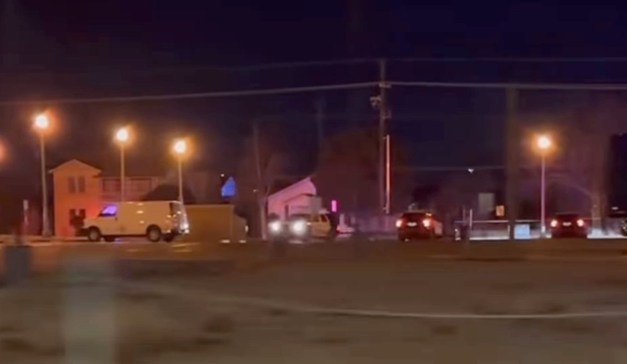 Nighttime scene near 18th Street and Avenue U in Lubbock showing police vehicles and flashing lights at the location of an officer-involved shooting investigation.