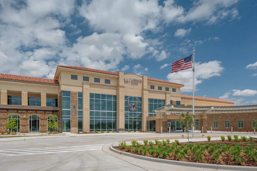 Exterior of the VA Lubbock Clinic in West Texas, a modern government healthcare building serving regional veterans under a blue sky with an American flag flying.