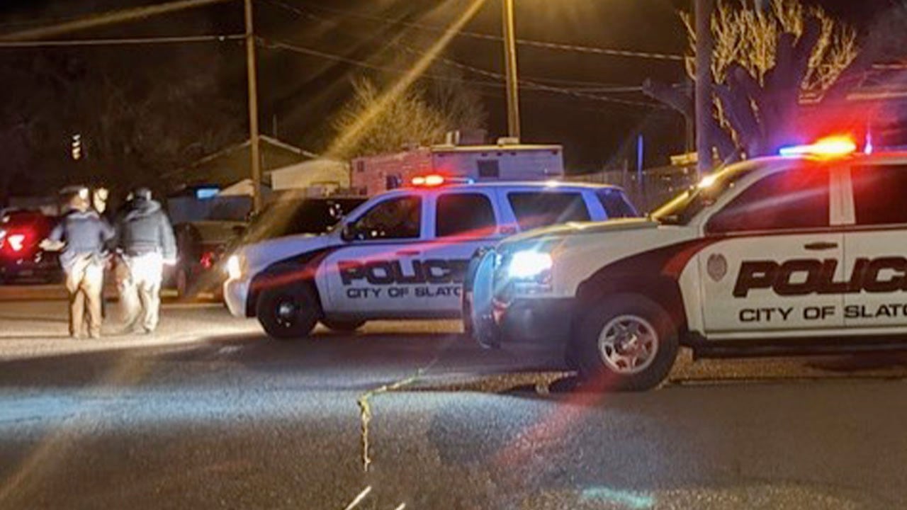 Slaton police SUVs with flashing lights blocking East Floyd Street at night as officers investigate a deadly shooting scene.