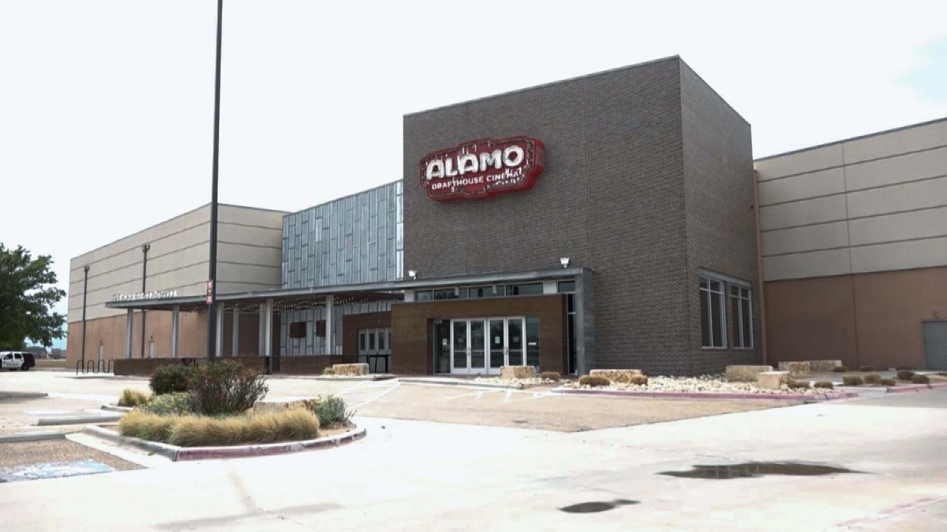 The exterior of the Alamo Drafthouse Cinema in Lubbock, Texas, showing its brick facade and logo above the entrance.