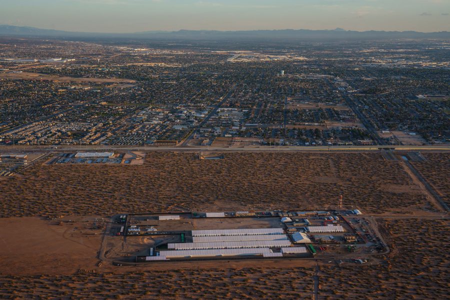 An aerial view shows the sprawling Camp East Montana detention center, a massive complex of white tents and temporary structures sitting in the middle of the El Paso desert, separated from the rest of civilization by a lot of dirt and a $1.2 billion contract.