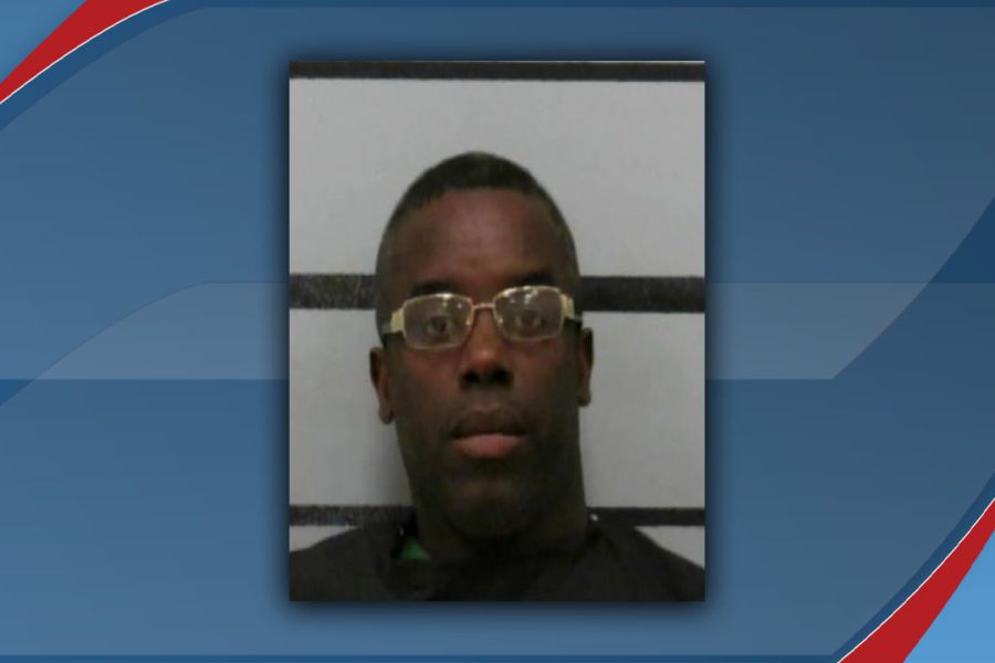 A mugshot of Charles Deeundray Green, who was arrested in Lubbock, Texas, on February 2, 2026, for multiple charges including aggravated assault with a deadly weapon. He is wearing gold-rimmed glasses and a dark shirt.
