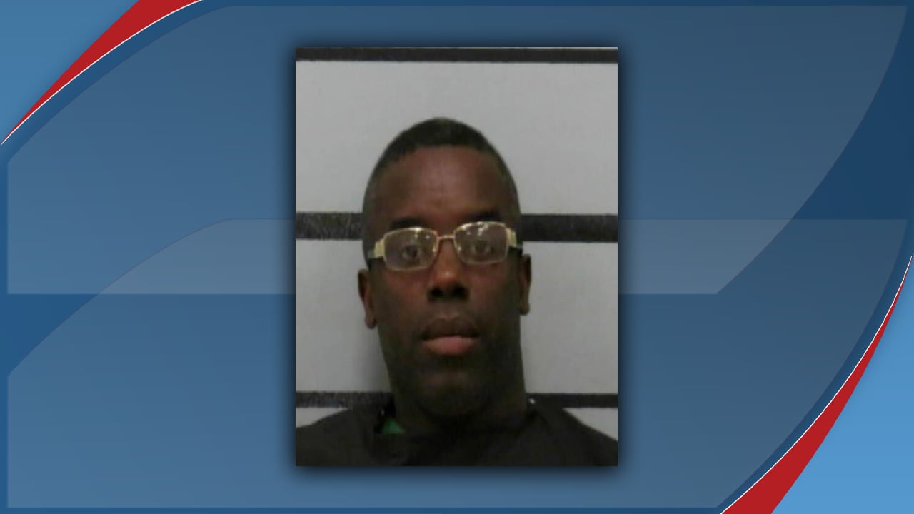 A mugshot of Charles Deeundray Green, who was arrested in Lubbock, Texas, on February 2, 2026, for multiple charges including aggravated assault with a deadly weapon. He is wearing gold-rimmed glasses and a dark shirt.