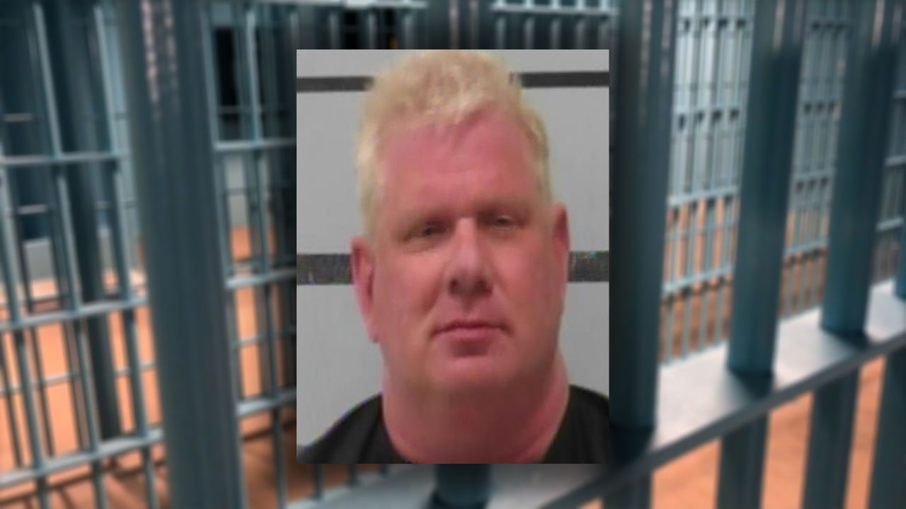 A mugshot of Texas Tech University marketing professor Daniel Taylor, looking remarkably like a man who just realized his "Pink Flamingo" supply chain didn't include a contingency plan for the DEA.