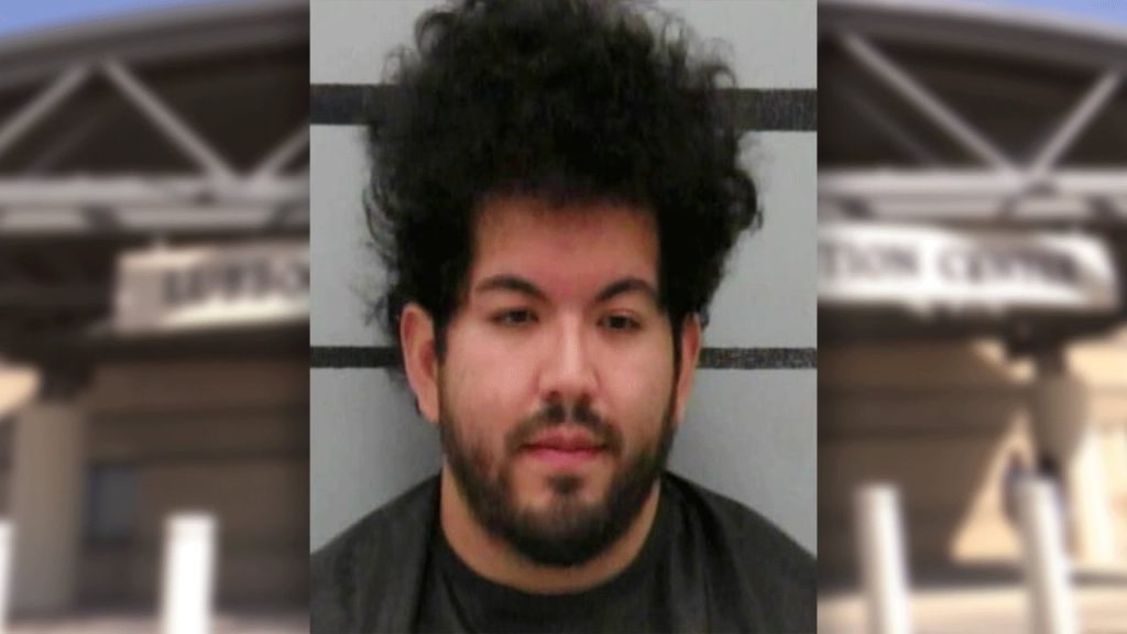 A mugshot of Joseph Gonzalez, former Shallowater band director, sporting a hairstyle that suggests he tried to conduct a lightning storm with his baton. He is pictured against the blurry backdrop of the Lubbock County Detention Center, where hair gel is presumably the least of his worries.