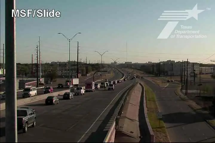 A grainy TxDOT traffic camera image showing a backup of vehicles on the Marsha Sharp Freeway overpass at Slide Road in Lubbock, Texas, during the morning commute where an emergency baby delivery took place on the shoulder.