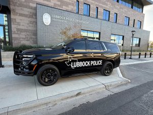 A black Lubbock Police Department SUV parked in front of the modern LPD headquarters building.