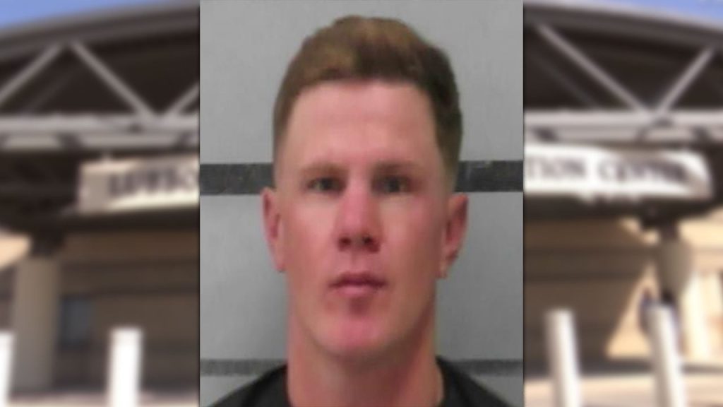 A mugshot of Seth Moore, a man with short blonde hair and a blank expression, appearing over a blurred background of the Lubbock County Detention Center.