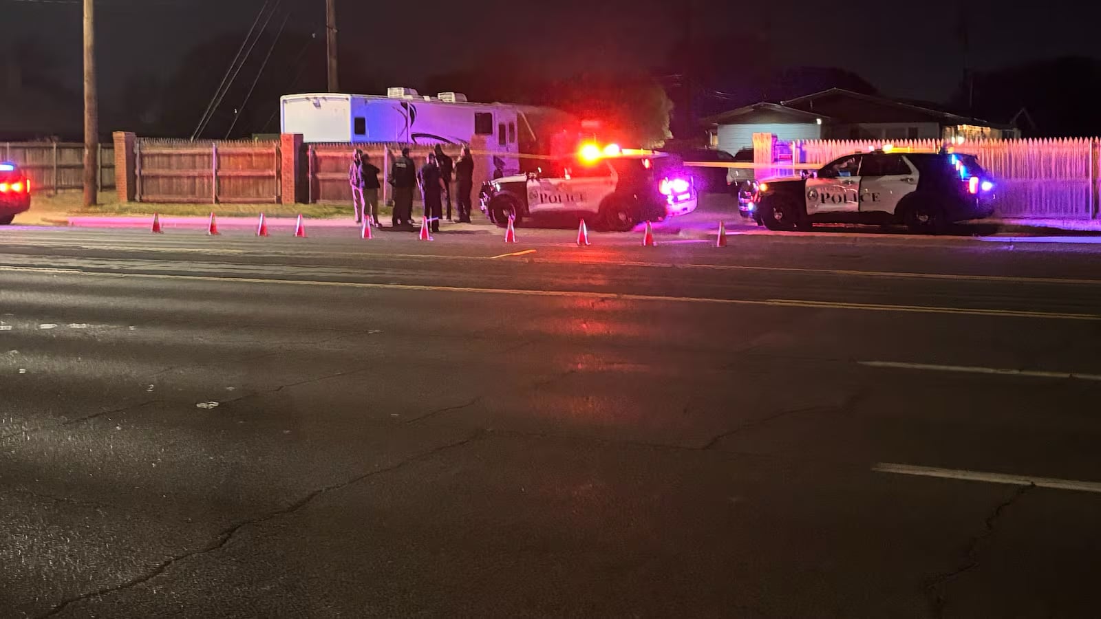 A nighttime scene in South Lubbock where multiple police SUVs with flashing lights and yellow crime tape have successfully blocked off a residential street, because nothing says "Friday morning" like a Metropolitan Special Crimes Unit investigation.